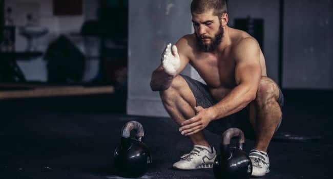 A man in a gym setting with kettlebells, illustrating how exercise can be a practical step in preparing for heroin withdrawal.