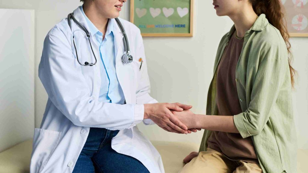 Doctor holding a patient’s hand in support, representing how short-term disability applies to dual diagnosis addiction rehab.
